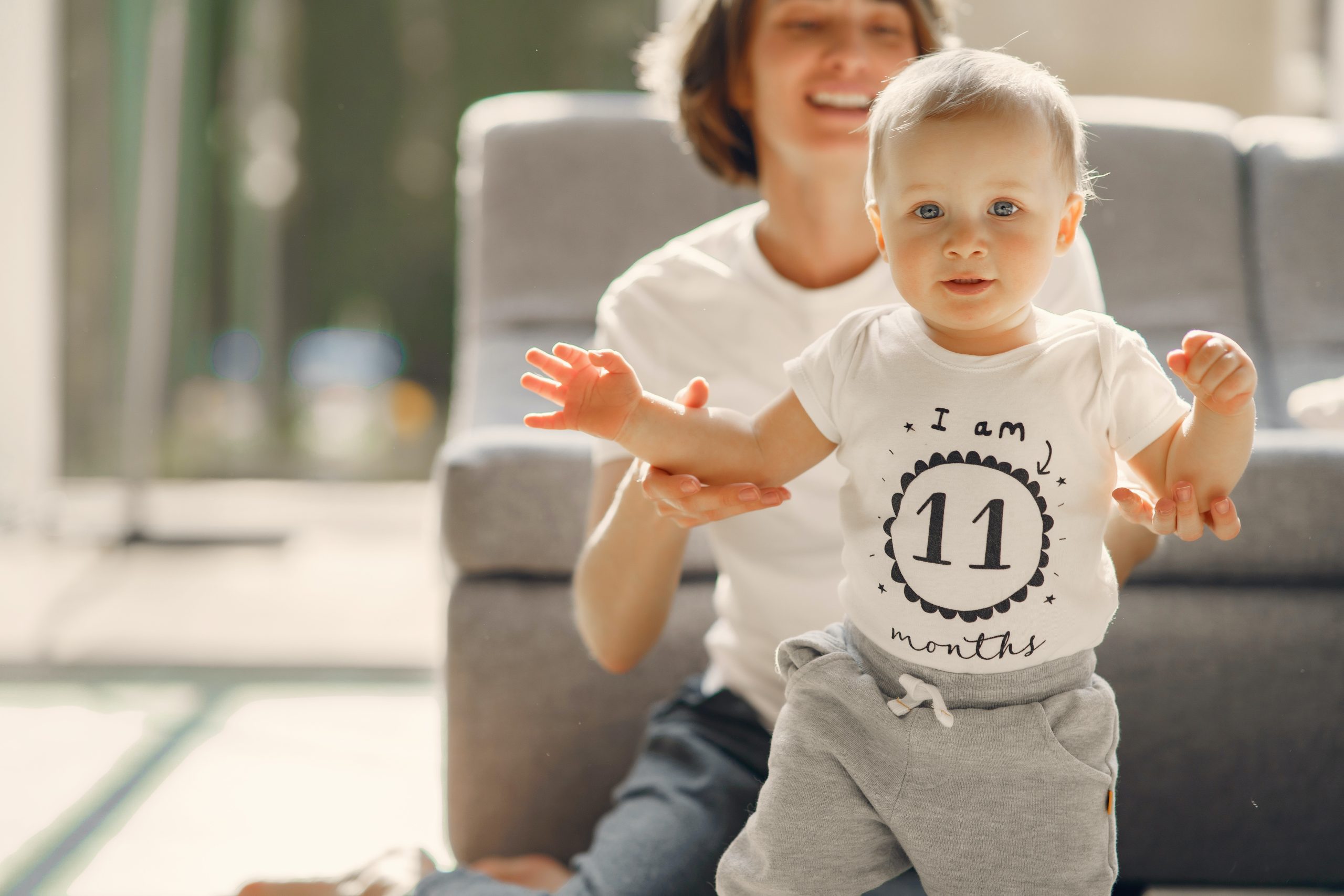 Young child taking first steps with a parent's support